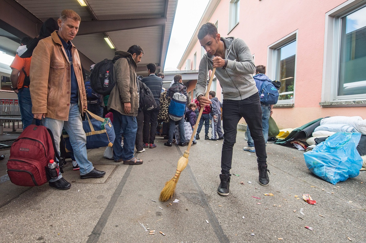 Freilassing, 2015. szeptember 16. Szíriai bevándorló seper a németországi Freilassing vasútállomásán 2015. szeptember 16-án. (MTI/EPA/Armin Weigel)