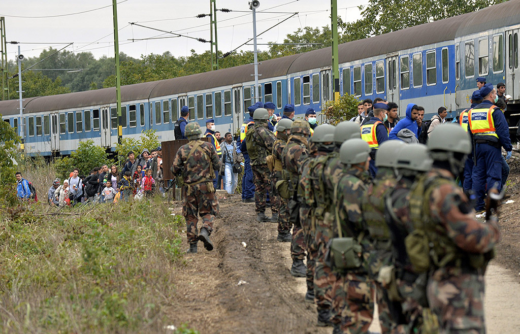 Zákány, 2015. szeptember 26. Migránsok haladnak a rendőrök és katonák sorfala mellett a gyékényesi vasútállomásnál, Zákány közelében 2015. szeptember 26-án. MTI Fotó: Máthé Zoltán