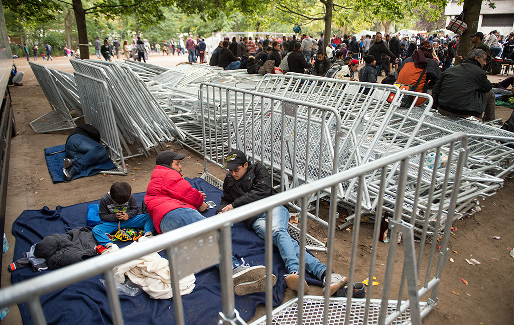 Berlin, 2015. szeptember 26. Illegális bevándorlók várakoznak fémkordonok mellett a menedékkérőket regisztráló egészségügyért és szociális ügyekért felelős tartományi hivatal, a LaGeSo egyik irodája előtt, Berlinben 2015. szeptember 26-án. (MTI/AP/Bernd Von Jutrczenka)