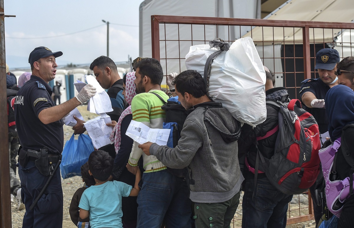 Gevgelija, 2015. szeptember 16. Görögország felõl Macedóniába érkezett illegális bevándorlók papírjait ellenõrzi egy rendõr egy regisztrációs táborban, a görög határ mellett fekvõ Gevgelija közelében 2015. szeptember 16-án. (MTI/EPA/Georgi Licovszki)
