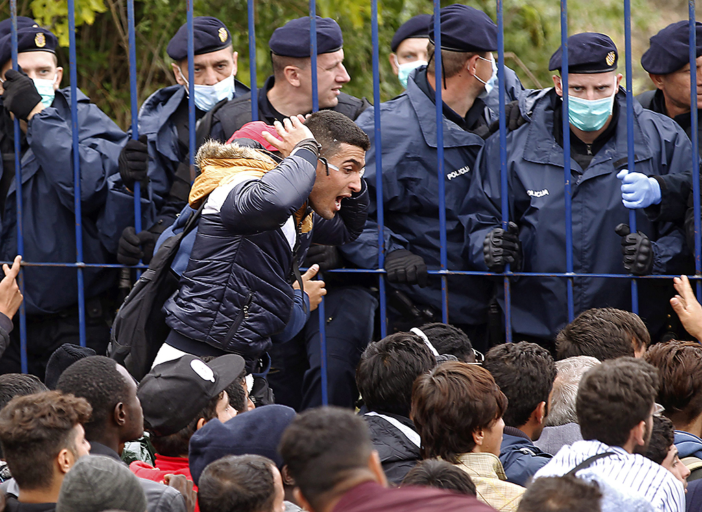 Berkasovo, 2015. szeptember 26. Horvát határőrök nyugalomra intik az illegális bevándorlókat, akik a szerbiai Berkasovóban várakoznak arra, hogy beengedjék őket Horvátországba 2015. szeptember 25-én. (MTI/EPA/Antonio Bat)
