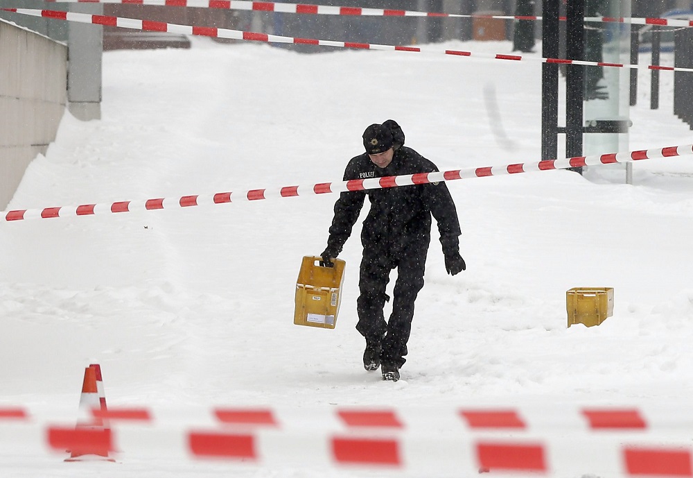 Egy rendőr sárga postai műanyagládával a kezében a berlini kancellária hivatal közelében. Fotó: MTI/AP/Michael Sohn