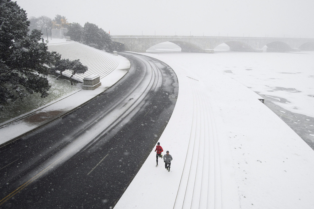 Washington, 2016. január 23. Kocogók futnak hóesésben a Potomac folyó partján Washingtonban 2016. január 22-én. A Jonas nevű hóvihar érkezése miatt az Egyesült Államok keleti államaiban hatvan-hetven centiméteres hóra számítanak. (MTI/EPA/Michael Reynolds)