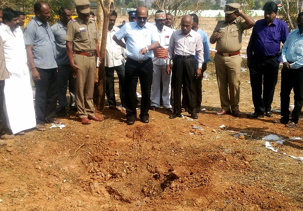 Indian authorities inspect the site of a suspected meteorite landing on February 7, 2016 in Vellore district in southern Tamil Nadu state in an impact that killed a bus driver and injured three others on February 6. If proven, it would be the first such death in recorded history. The impact of the object left a large crater in the ground and shattered window panes in a nearby building, killing the driver who was walking past. AFP PHOTO / AFP / STR