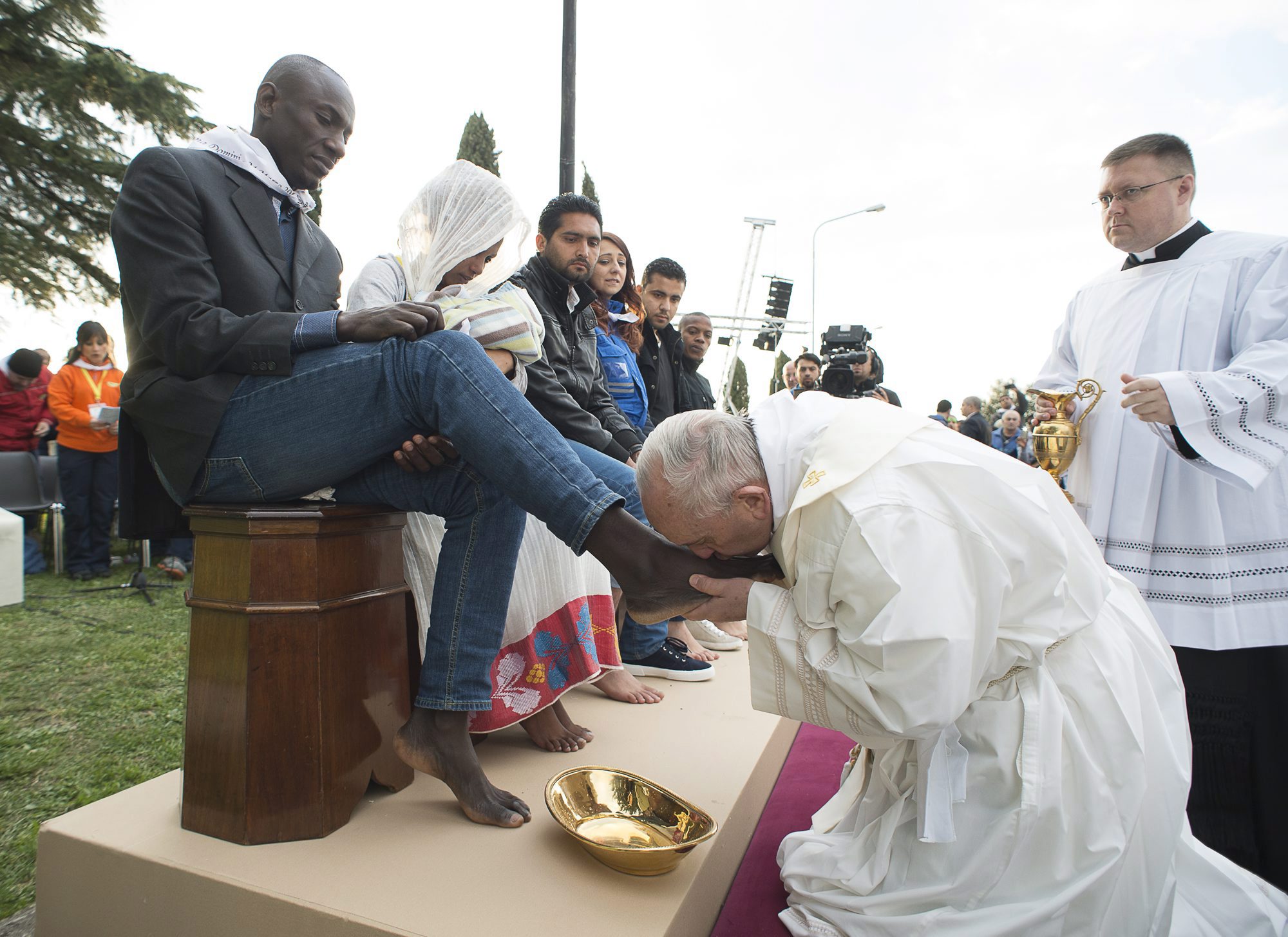 Castelnuovo di Porto, 2016. március 24. Ferenc pápa megcsókolja egy férfi lábfejét az utolsó vacsorára emlékezõ nagycsütörtöki mise alkalmával tartott lábmosás szertartáson a Rómától harminc kilométerre levõ Castelnuovo di Porto menekülttáborában 2016. március 24-én. A katolikus egyházfõ a rituálé során tizenegy menekültnek - köztük muzulmánoknak, kopt keresztényeknek és egy hindunak -, valamint egy táborban dolgozó önkéntesnek mosta meg a lábát. (MTI/AP pool/L'Osservatore Romano)