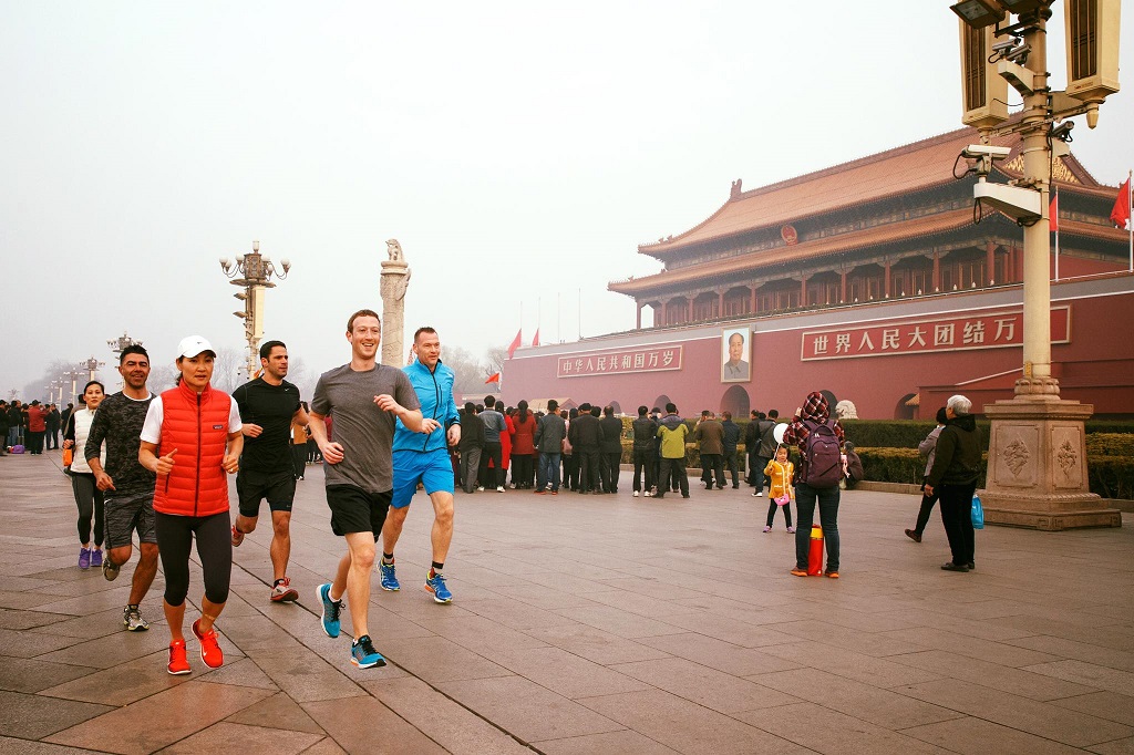 Facebook CEO Mark Zuckerberg (front R, grey shirt) jogs through a smog-wreathed Tiananmen Square, Beijing, China, on March 18, 2016. (Facebook via EyePress)