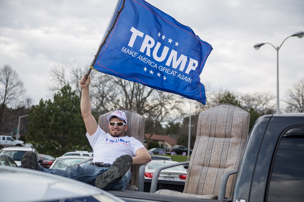 UNITED STATES, West Allis: A Trump supporter waves a blue flag with Donald Trump's political campaign catchphrase on it as Republican presidential candidate Donald Trump speaks to guests during a campaign stop at Nathan Hale High School on April 2, 2016 in West Allis, Wisconsin. Wisconsin voters go to the polls for the state's primary on April 5, 2016. - Jonah White