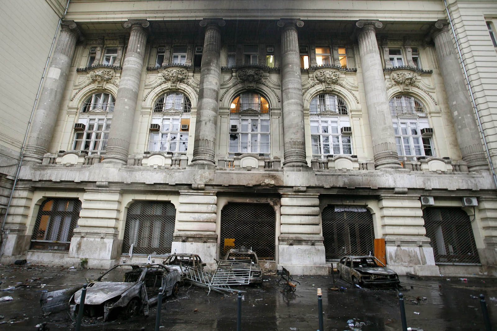 Kiégett, megrongált, összetört gépkocsik a Magyar Televízió (MTV) Szabadság téri székháza előtt, miután a tüntetők megpróbálták elfoglalni az intézményt. A felgyújtott és kiégett autókon, a televízió épületéből kihordott, összetört és szétdobált berendezési tárgyakon fellelhető nyomokat rögzítenek a bűnügyi technikusok. Budapest, 2006. szeptember 19. MTI Fotó: Füzesi Ferenc