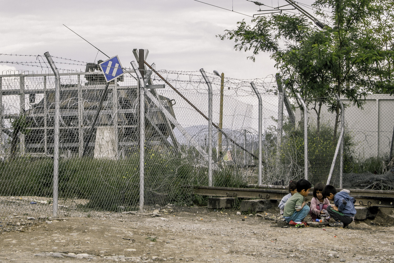 Menekült gyerekek játszanak a macedón határkerítés tövében Idomeni mellett. Fotó: Kaufmann Balázs