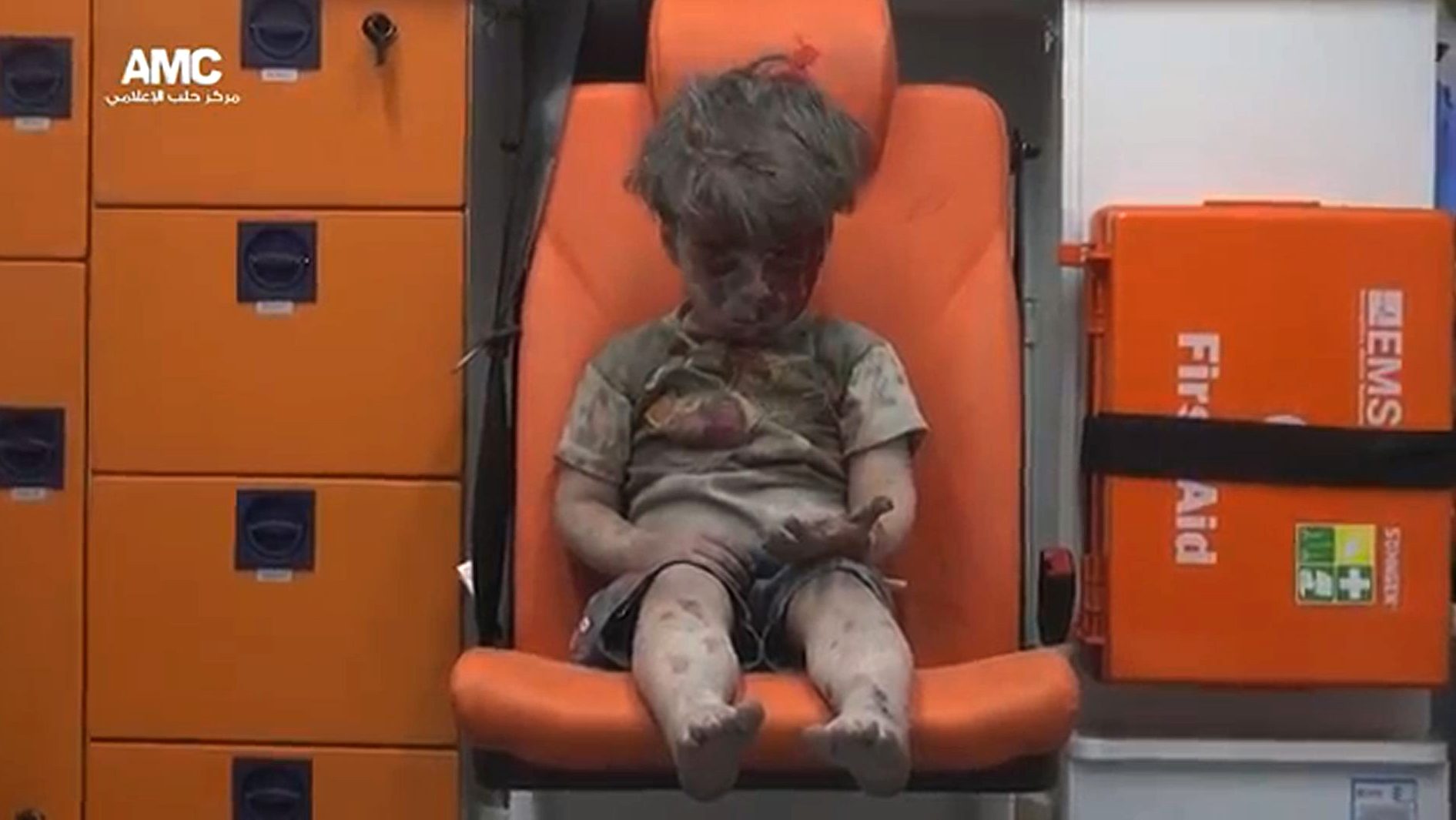 An image grab taken from a video uploaded by the Syrian opposition's activist group Aleppo Media Centre (AMC) on August 17, 2016 is said to show Omran, a four-year-old Syrian boy covered in dust and blood, looking at his hand in shock as he sits in an ambulance after being rescued from the rubble of a building hit by an air strike in the rebel-held Qaterji neighbourhood of the northern Syrian city of Aleppo. / AFP PHOTO / AMC / HO / === RESTRICTED TO EDITORIAL USE - MANDATORY CREDIT "AFP PHOTO / HO / AMC " - NO MARKETING NO ADVERTISING CAMPAIGNS - DISTRIBUTED AS A SERVICE TO CLIENTS FROM ALTERNATIVE SOURCES, AFP IS NOT RESPONSIBLE FOR ANY DIGITAL ALTERATIONS TO THE PICTURE'S EDITORIAL CONTENT, DATE AND LOCATION WHICH CANNOT BE INDEPENDENTLY VERIFIED ===   /