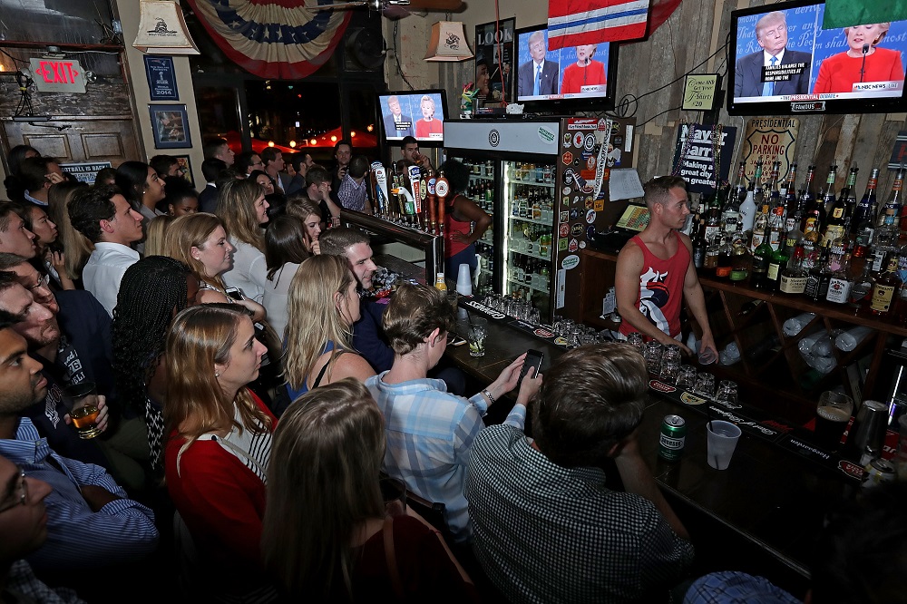WASHINGTON, DC - SEPTEMBER 26: Patrons fill the Capitol Lounge two blocks from the U.S. Capitol to watch the first presidential debate between Republican candidate Donald Trump and Democratic candidate Hillary Clinton September 26, 2016 in Washington, DC. The historic one-and-a-half hour debate was broadcast on CNN. Chip Somodevilla/Getty Images/AFP