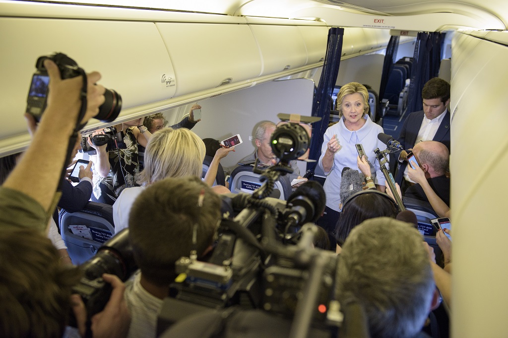 Democratic presidential nominee Hillary Clinton speaks to the press onboard her plane September 5, 2016 above Iowa. / AFP PHOTO / Brendan Smialowski