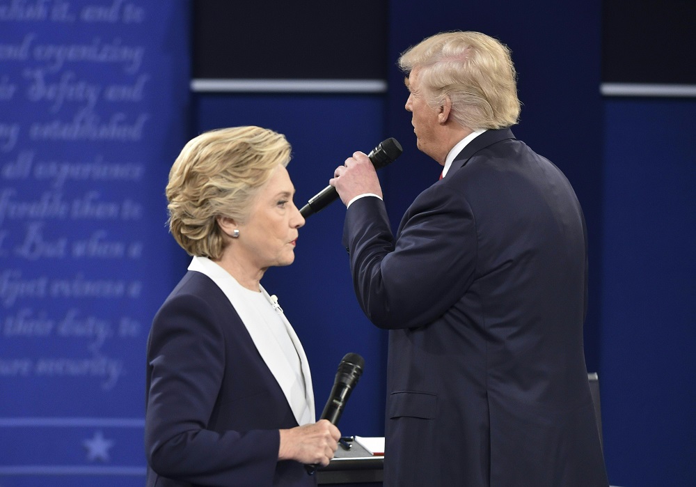 Republican presidential candidate Donald Trump speaks as Democratic presidential candidate Hillary Clinton listens during the second presidential debate at Washington University in St. Louis, Missouri on October 9, 2016. / AFP PHOTO / Paul J. Richards