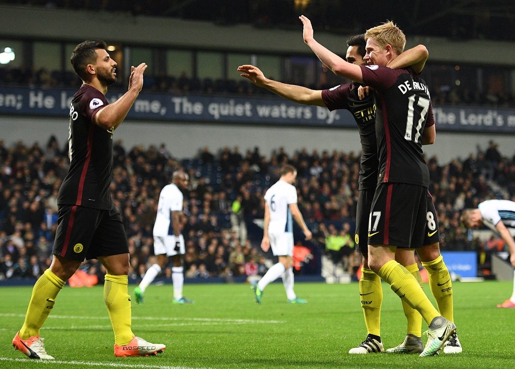 Manchester City's German midfielder Ilkay Gundogan (2nd R) celebrates with Manchester City's Belgian midfielder Kevin De Bruyne and Manchester City's Argentinian striker Sergio Aguero (L) after scoring their fourth goal during the English Premier League football match between West Bromwich Albion and Manchester City at The Hawthorns stadium in West Bromwich, central England, on October 29, 2016. Manchester City won the game 4-0. / AFP PHOTO / Justin TALLIS / RESTRICTED TO EDITORIAL USE. No use with unauthorized audio, video, data, fixture lists, club/league logos or 'live' services. Online in-match use limited to 75 images, no video emulation. No use in betting, games or single club/league/player publications. /