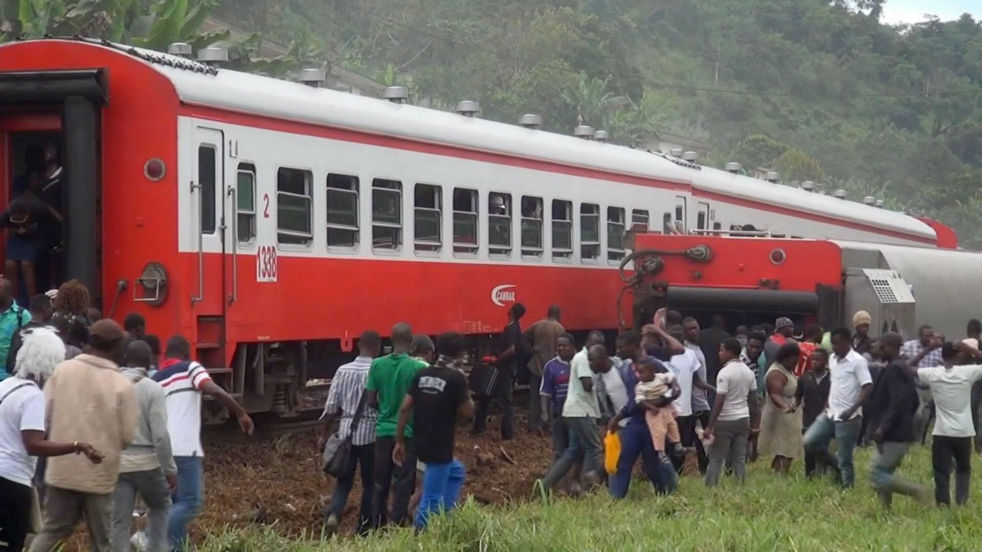 Eseka, 2016. október 22. A videofelvételrõl készített képen oldalára dõlt vasúti kocsi mellett emberek 2016. október 21-én, miután kisiklott egy vonat a kameruni Esakában. A balesetben legalább 53 ember életét vesztette. (MTI/AP/Equinox TV)