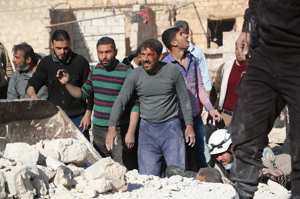 ALEPPO, SYRIA - NOVEMBER 25: Civil defense members and citizens carry out search and rescue works on the debris of the collapsed buildings after the war crafts belonging to Russian Army carried out airstrikes on the opposition controlled residential areas in Takad town of Aleppo, Syria on November 25, 2016. It is reported that 7 people killed and 20 wounded after the attack. (Photo by Beha El Halebi/Anadolu Agency/Getty Images)