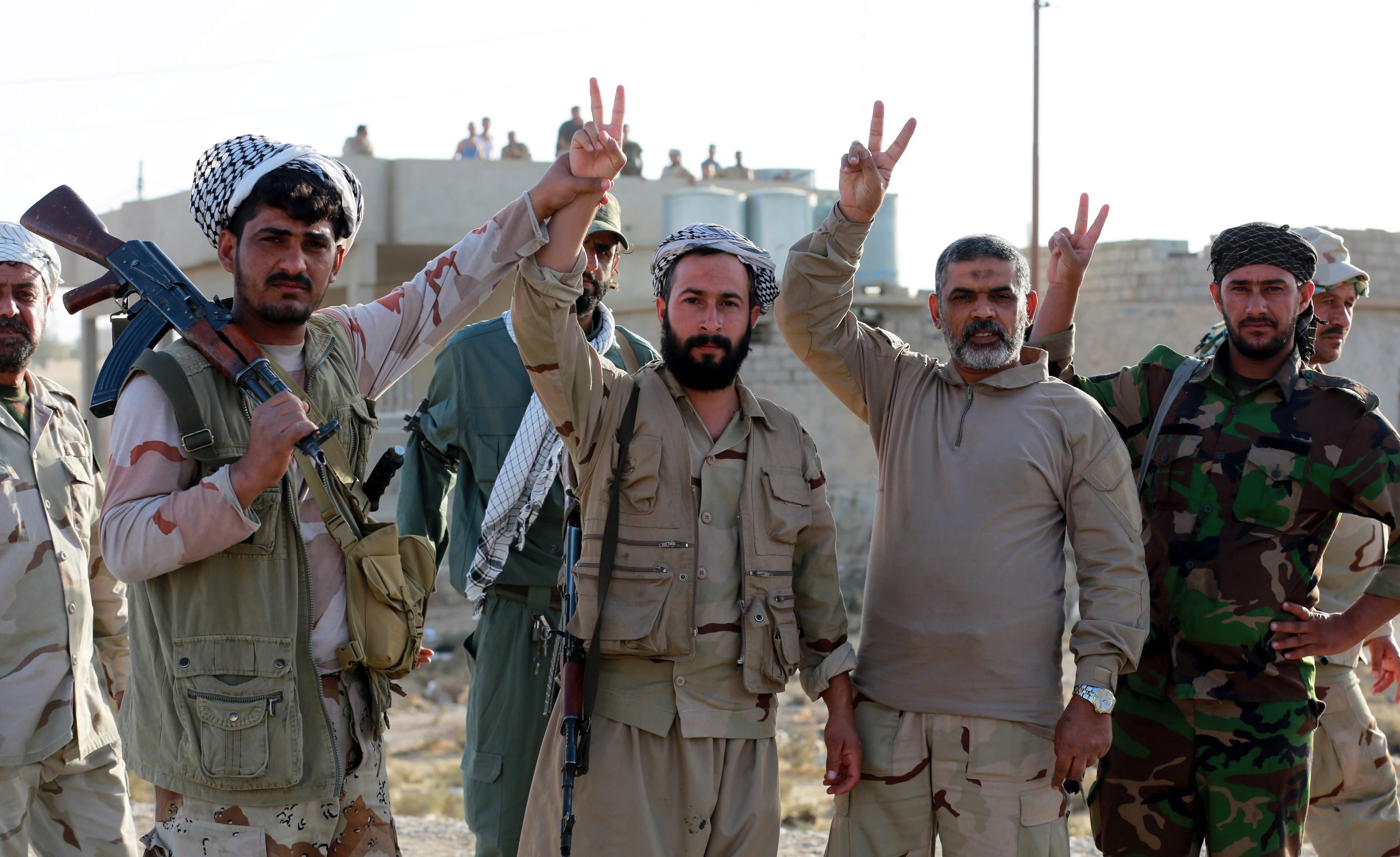 Zarka, 2016. november 1. Iraki síita fegyveresek a gyõzelem jelét mutatják az ostromgyûzûbe zárt észak-iraki Moszultól mintegy 20 kilométerre, nyugatra fekvõ és a napokban felszabadított Zarkában 2016. október 31-én. Az iraki kormányhadsereg és a vele szövetséges kurd erõk, továbbá szunnita törzsek és az Irán támogatta síita milíciák október 17-én kezdtek nagyszabású hadmûveletet Moszul és környéke visszafoglalására az Iszlám Állam dzsihadista szervezet fegyvereseitõl. (MTI/EPA/Ahmed Dzsalil)