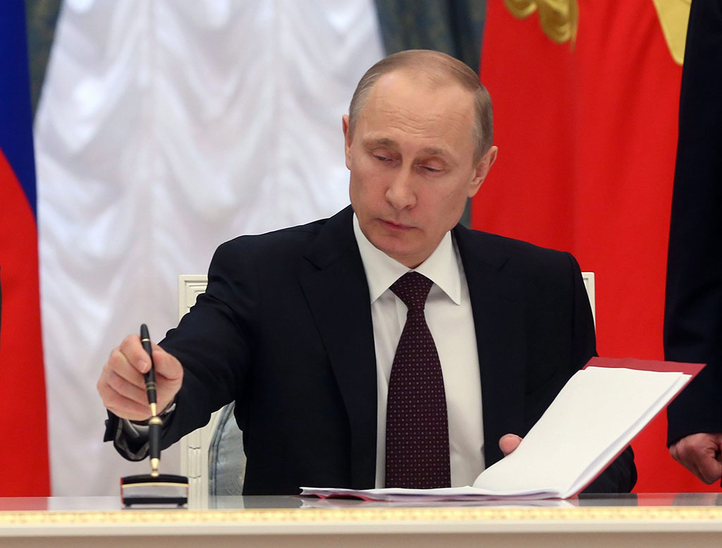 Vlagyimir Putyin orosz elnök aláírja a Krím félsziget és Szevasztopol Oroszországhoz való csatlakozásához szükséges alkotmánymódosítási törvényt a moszkvai Kremlben 2014. március 21-én. Fotó: MTI / EPA / Szergej Csirikov