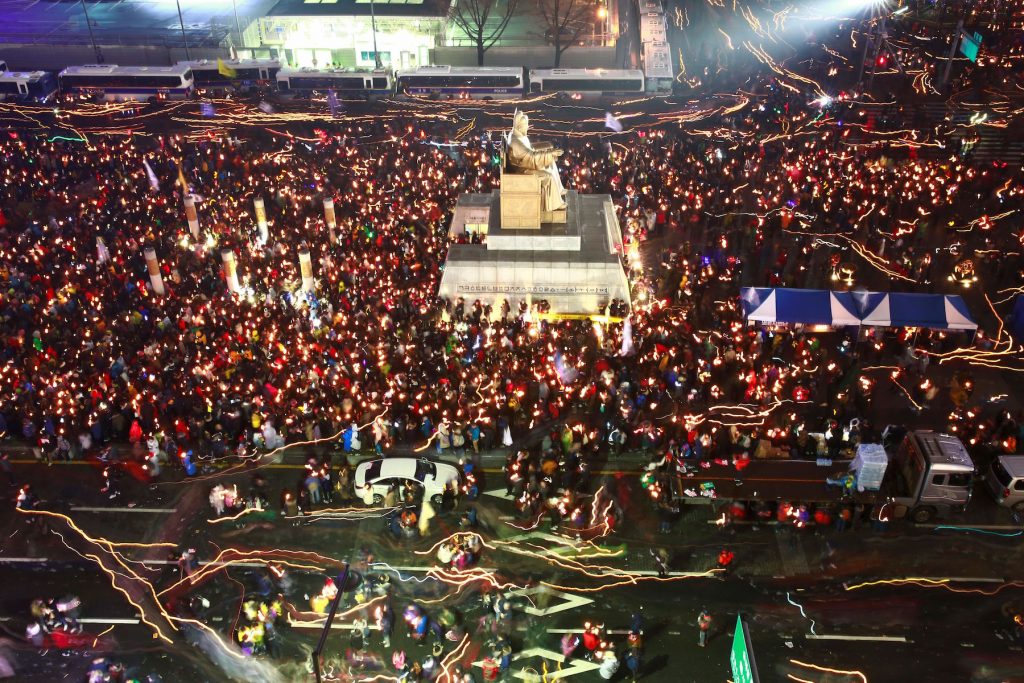 South Korean protesters take part in a candlelight procession towards the presidential house during a rally against South Korean President Park Geun-Hye in Seoul on November 26, 2016. Tens of thousands of protesters braved sleet and freezing temperatures in Seoul on November 26 to demand Park resign over a corruption scandal or face impeachment.   / AFP PHOTO / POOL / JEON HEON-KYUN