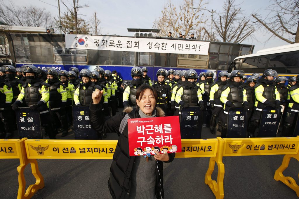 Szöul, 2016. december 3. Egy tüntetõ rendõrök sorfala elõtt követeli a korrupciós botrányba keveredett Pak Gun Hje dél-koreai elnök lemondását Szöulban 2016. december 3-án. (MTI/EPA/Dzson Hon Kjun)