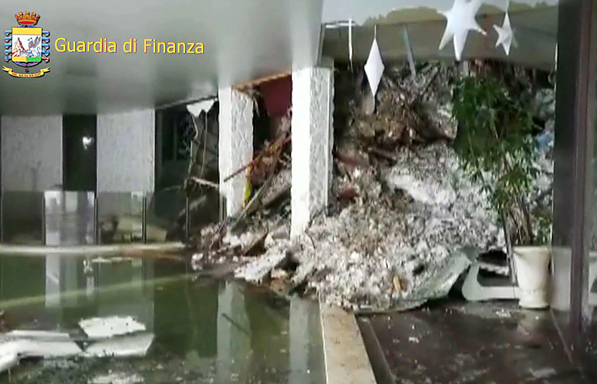 This image grab made from a video handout released by the Guardia di Finanza on January 19, 2017 shows a wall of snow engulfing the inside of the Hotel Rigopiano, near the village of Farindola, on the eastern lower slopes of the Gran Sasso mountain. Up to 30 people were feared to have died after an Italian mountain Hotel Rigopiano was engulfed by a powerful avalanche in the earthquake-ravaged centre of the country. Italy's Civil Protection agency confirmed the Hotel Rigopiano had been engulfed by a two-metre (six-feet) high wall of snow and that emergency services were struggling to get ambulances and diggers to the site. / AFP PHOTO / Guardia di Finanza press office / Handout / RESTRICTED TO EDITORIAL USE - MANDATORY CREDIT "AFP PHOTO / GUARDIA DI FINANZA " - NO MARKETING NO ADVERTISING CAMPAIGNS - DISTRIBUTED AS A SERVICE TO CLIENTS