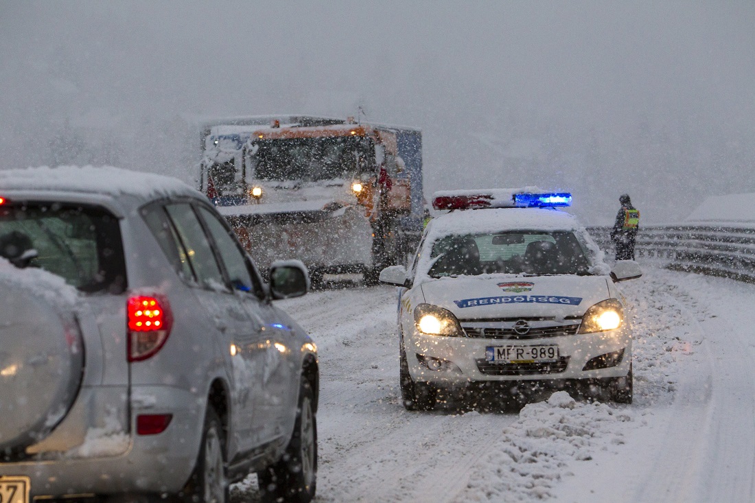 Nagykanizsa, 2017. január 13. Rendõrök állítják meg a forgalmat a sûrû hóesésben a 61-es úton Nagykanizsánál, ahol sószóró dolgozik, mert jármûvek akadtak el 2017. január 13-án. MTI Fotó: Varga György