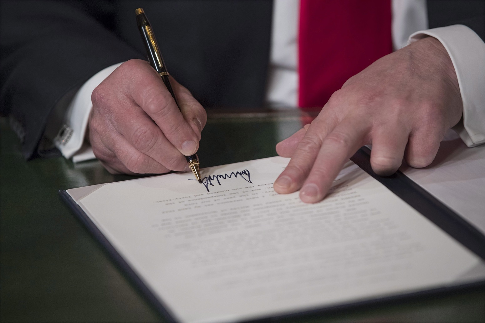Washington, 2017. január 20. Donald Trump, az Egyesült Államok 45. elnöke kézjegyével látja el a beiktatási dokumentumokat Washingtonban 2017. január 20-án. (MTI/EPA pool/J. Scott Applewhite)