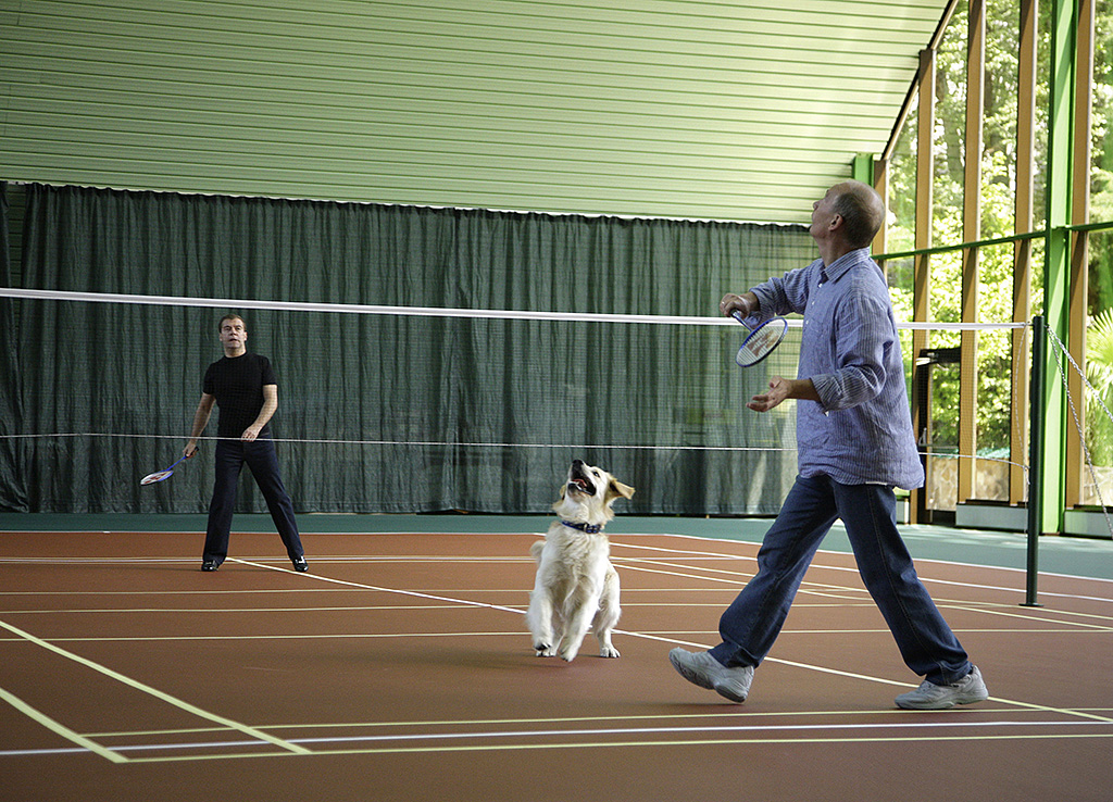 Russian President Dmitry Medvedev (L) and Prime Minister Vladimir Putin, accompanied by a dog, play badminton at the presidential residence in Sochi on August 14, 2009. Putin and Medvedev recently spent a night on the town watching the Russian national football team in action at a local bar. AFP PHOTO / RIA NOVOSTI / KREMLIN POOL / DMITRY ASTAKHOV / AFP PHOTO / RIA NOVOSTI / DMITRY ASTAKHOV