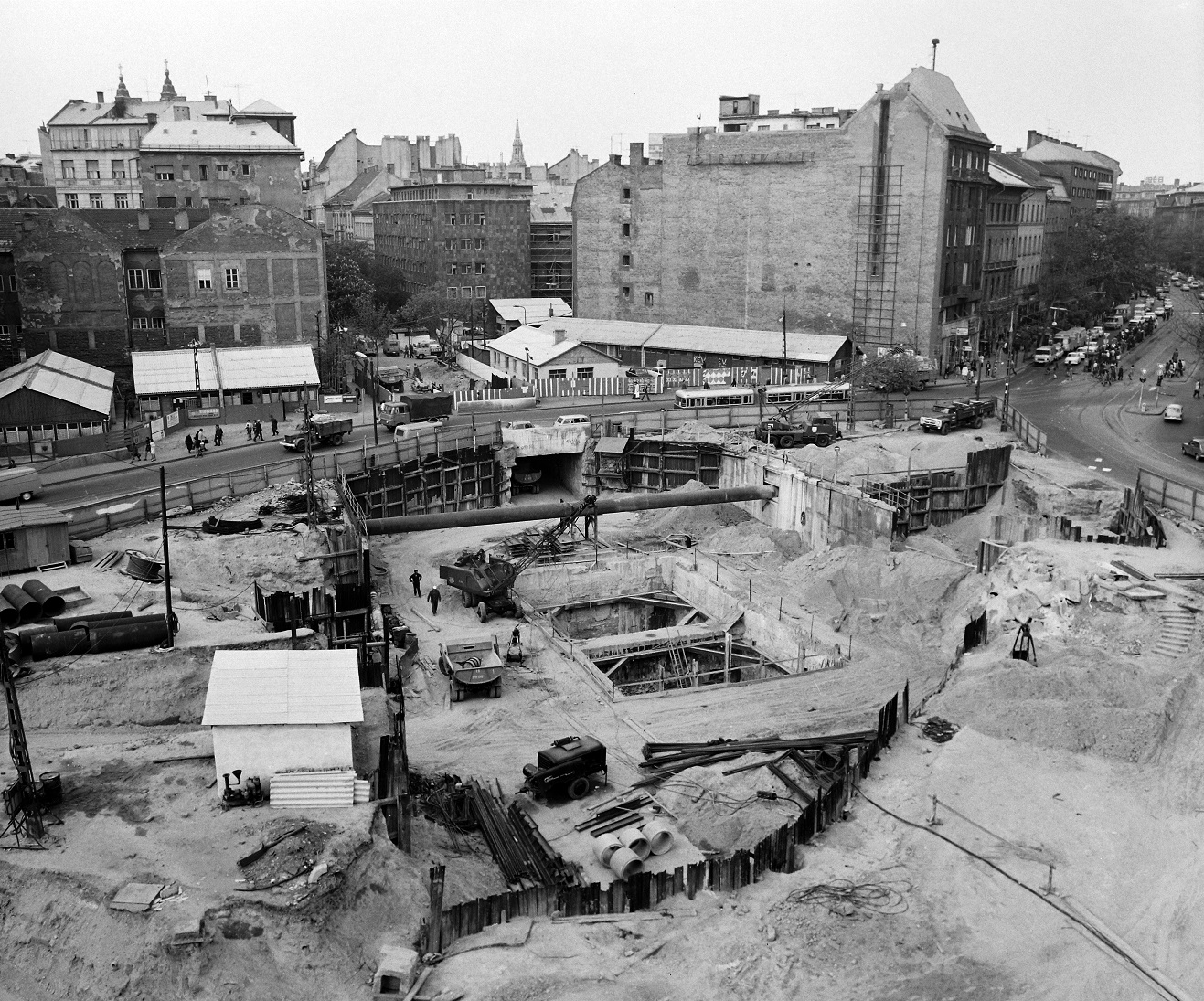 A 4-es metró előtt már egyszer, 1975-ben feltúrták a Kálvin teret, hogy a hármas metróhoz vezető részt és az aluljárót kiépíthessék. De mi az a nagy üresség ott szemben? Bizony, a szállodák még hiányoznak a Kecskeméti utca bejáratától. Fotó: Fortepan.hu