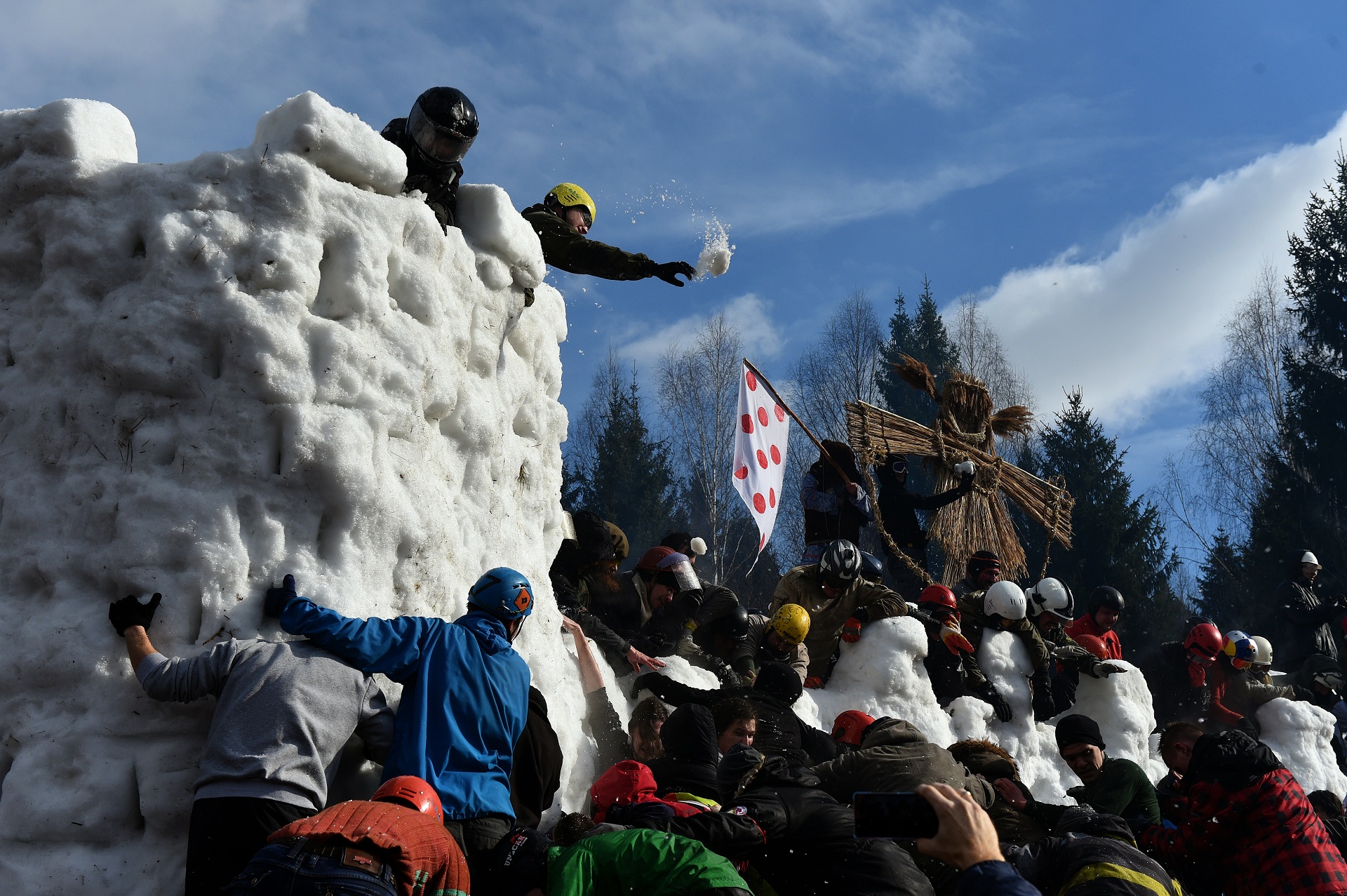 People storm a snow fortress close to the village of Abramtsevo, 60 km north of Moscow on March 13, 2016, in celebration of Maslenitsa (Shrovetide), a farewell ceremony to winter. Shrovetide precedes the beginning of Lent, with each day of the week holding its own meaning. Shrove Sunday, also known as the Sunday of Forgiveness, is a day for asking forgiveness for the harm caused to other people intentionally or unintentionally. / AFP PHOTO / VASILY MAXIMOV