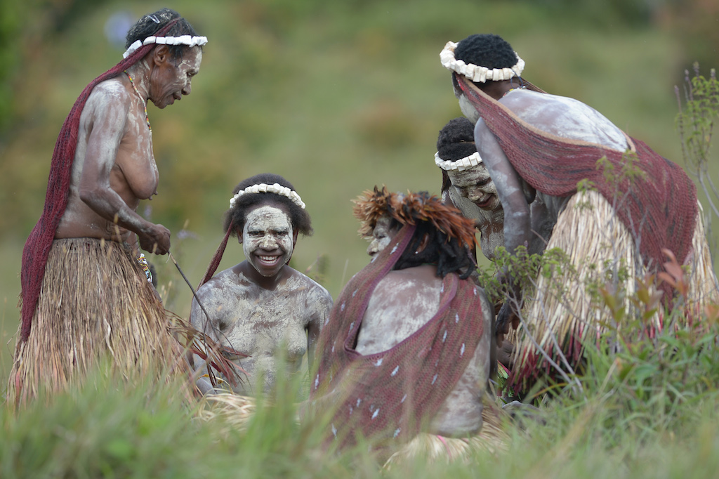 In this photo taken on August 9, 2016, Dani tribeswomen participate in the 27th annual Baliem Valley Festival in Walesi district in Wamena, Papua Province. Performances at the 27th Baliem Valley Festival, taking place from August 8 to 10, feature mock battles of highland tribes of Dani, Yali and Lani to symbolise the high spirit and power that have been practised for generations. / AFP PHOTO / ADEK BERRY