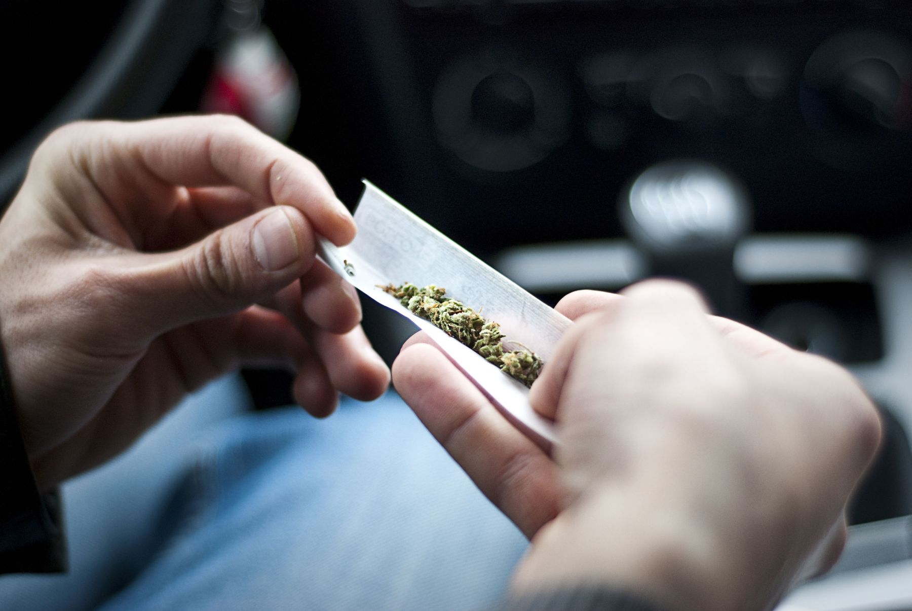 59953123 - man making joint and a stash of marijuana in the car