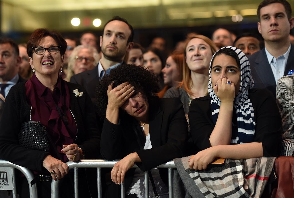 People watch elections returns during election night at the Jacob K. Javits Convention Center in New York on November 8, 2016. US Democratic presidential nominee Hillary Clinton will hold her election night event at the convention center. / AFP PHOTO / DON EMMERT