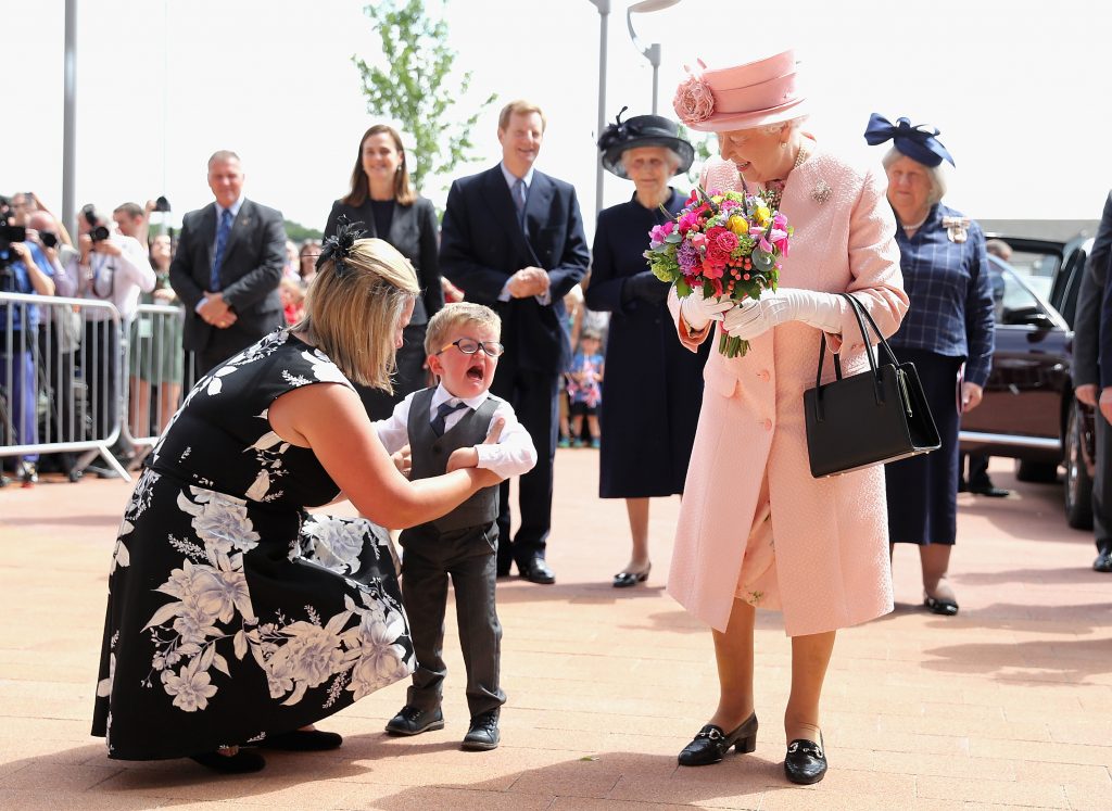 LIVERPOOL, ENGLAND - JUNE 22: Two year old Lewis Connet bursts into tears as he presents Queen Elizabeth II with flowers as she arrives with the Duke of Edinburgh to officially open Alderhey Children's Hospital during a visit to Liverpool on June 22, 2016 in Liverpool, England. (Photo by Chris Jackson-WPA Pool/Getty Images)