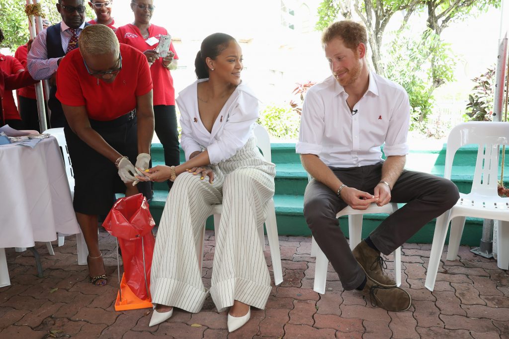 BRIDGETOWN, BARBADOS - DECEMBER 01: Prince Harry (R) watches as Singer Rihanna (L) gets her blood sample taken for an live HIV test, in order to promote more widespread testing for the public at the 'Man Aware' event held by the Barbados National HIV/AIDS Commission on the eleventh day of an official visit on December 1, 2016 in Bridgetown, Barbados. Prince Harry's visit to The Caribbean marks the 35th Anniversary of Independence in Antigua and Barbuda and the 50th Anniversary of Independence in Barbados and Guyana. (Photo by Chris Jackson - Pool/Getty Images)