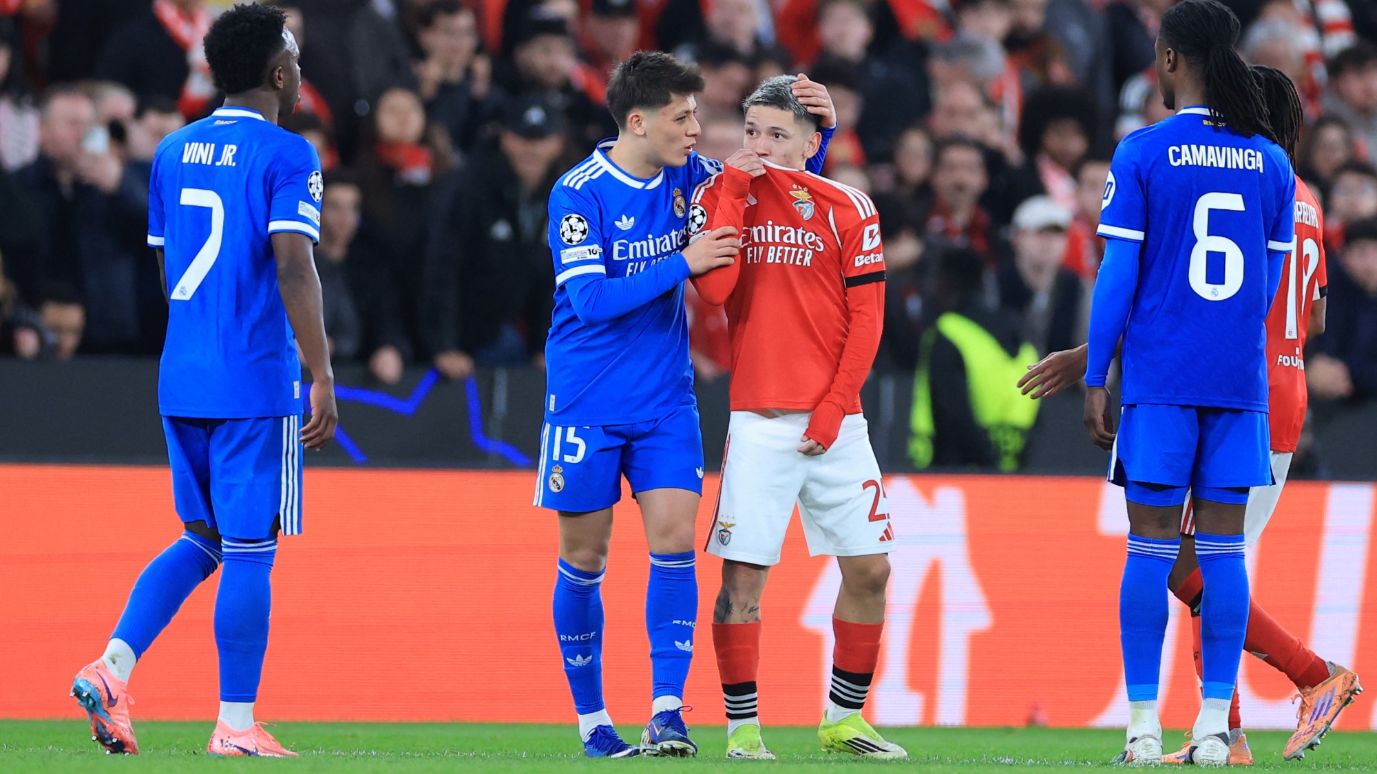 Gianluca Prestianni, miközben a száját eltakarva odaszól Vinícius Juniornak.